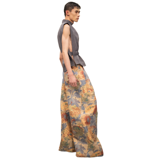 Person wearing a sleeveless top and floral pants on a white background