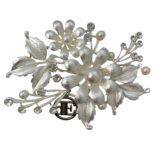 Silver floral brooch with pearls and crystals on a light gray background