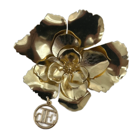 Gold floral brooch with a pendant on a white background