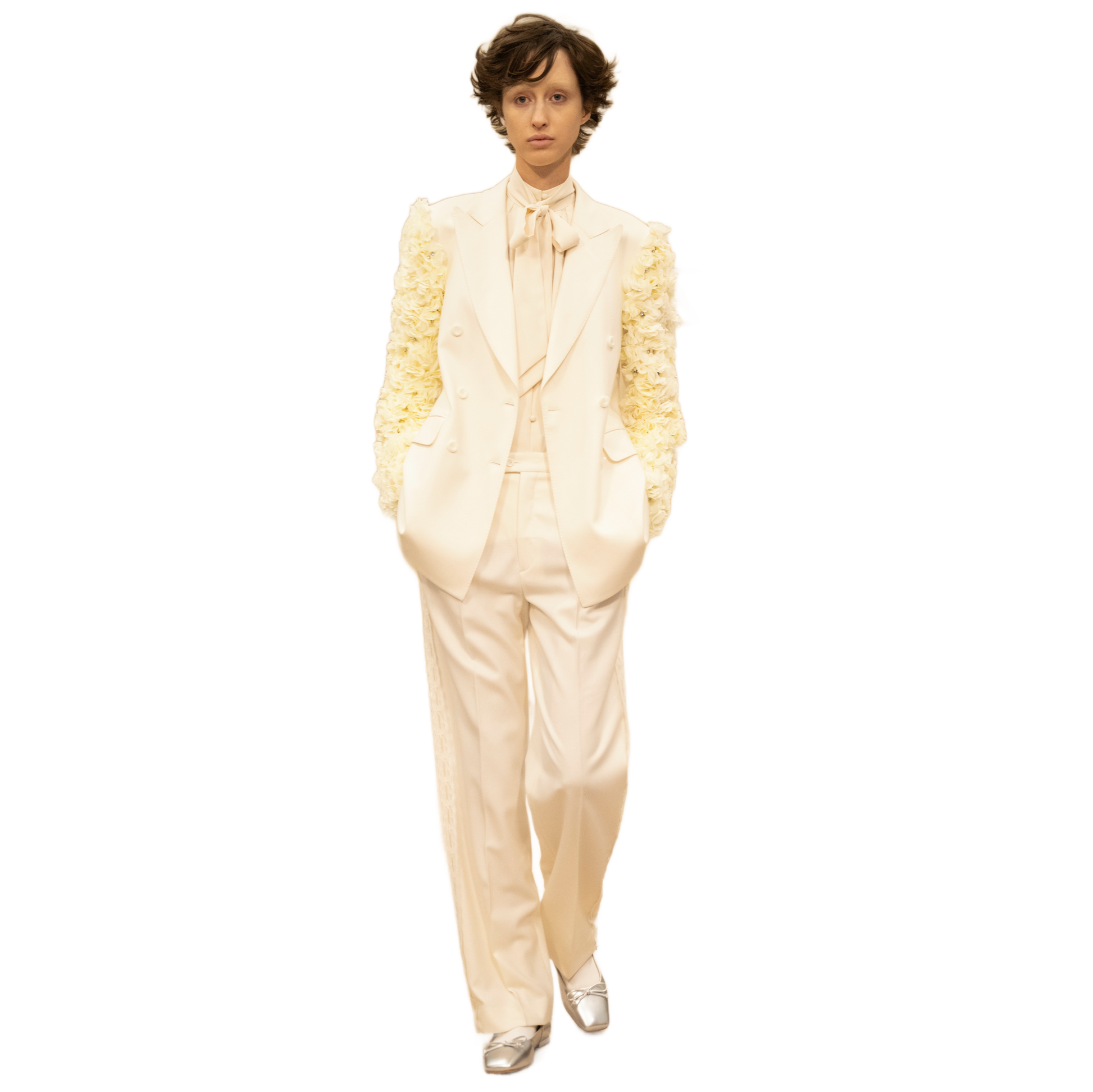 Person wearing a cream-colored suit with a textured jacket on a white background