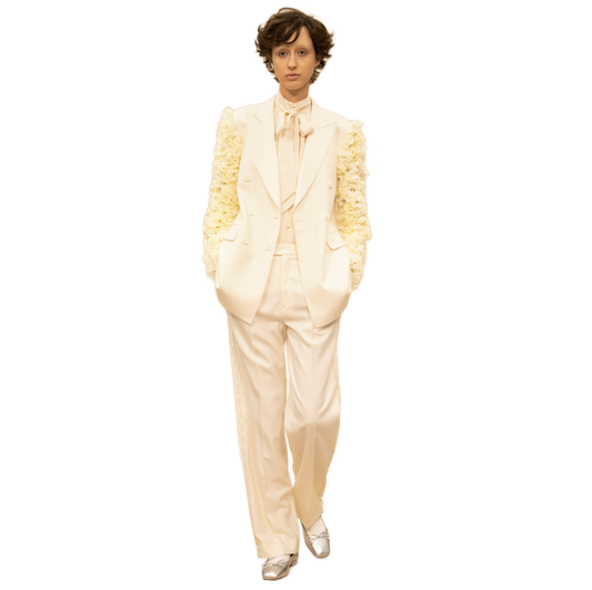 Person wearing a cream-colored suit with a textured jacket on a white background