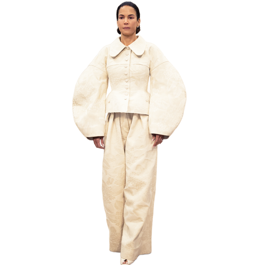 Model wearing a cream-colored jacket on a white background