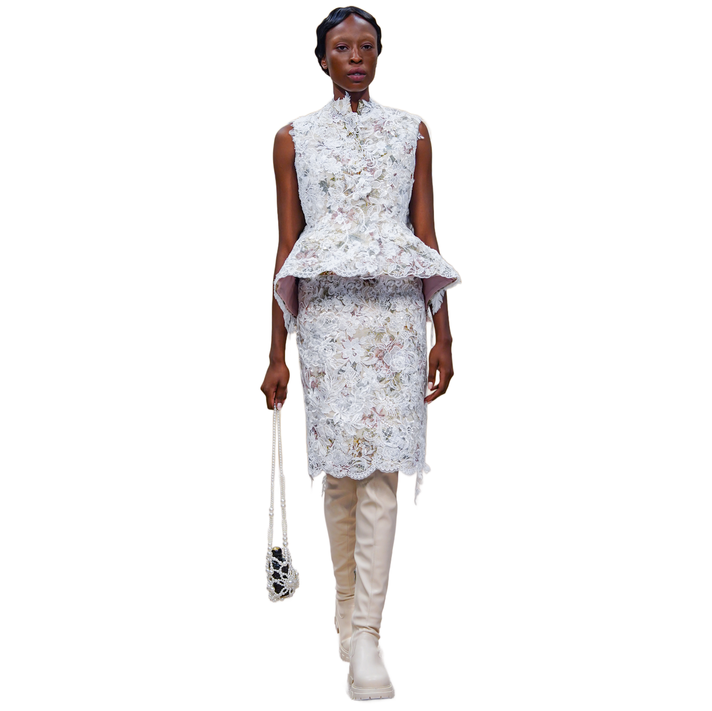 Woman wearing a floral peplum top and skirt with beige boots on a white background