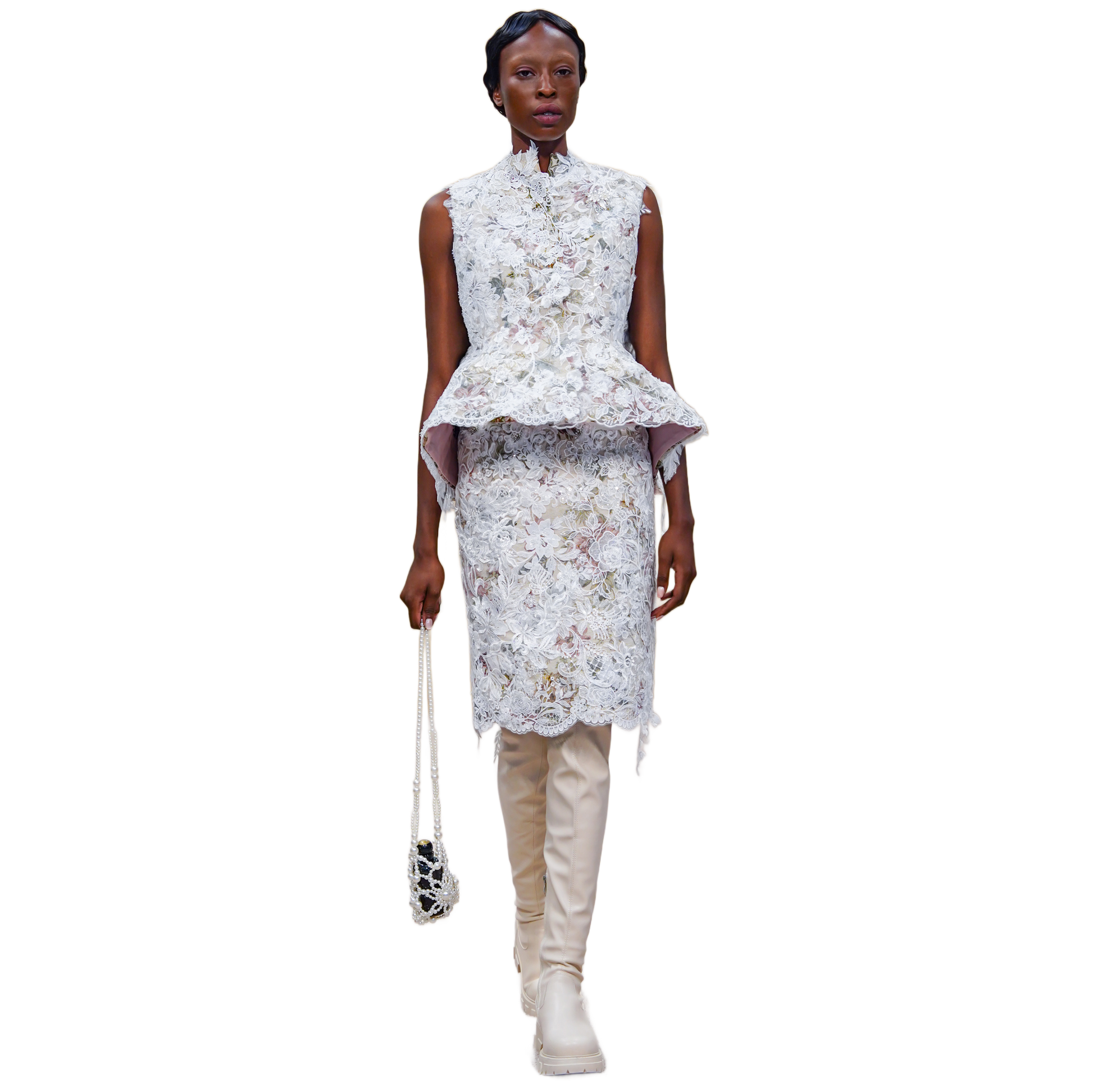 Woman wearing a floral peplum top and skirt with beige boots on a white background